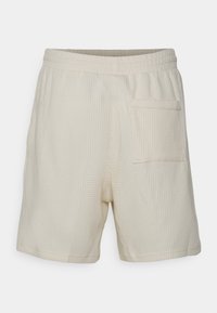 Krémové šortky s texturovaným, vaflovým vzorem. Mají elastický pas a jednu zadní kapsu.