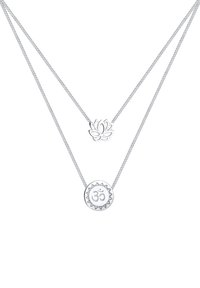 Collier superposé en ton argent avec un pendentif fleur de lotus et un pendentif symbole "Om", tous deux sur des chaînes délicates aux surfaces polies.
