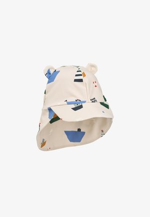 Chapeau bob en tissu crème avec un imprimé nautique de bateaux et de phares. Présente deux petites attaches en forme d'oreilles sur le dessus.