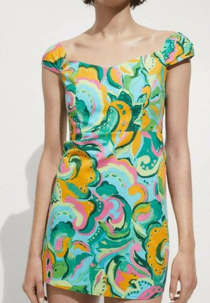 Abito corto colorato in un tessuto leggero e morbido, caratterizzato da un vivace motivo a vortice di verde, rosa e giallo, con maniche a cappuccio scese sulle spalle.