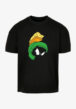 Černé tričko s potiskem hlavy kreslené postavičky v zelené a oranžové barvě. Design zahrnuje velké, expresivní oči a stylizovanou přilbu.