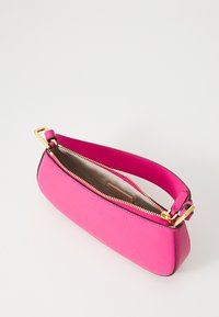 Pink leather handbag with gold zipper, flat design, and a rounded shape. Features a short handle and a smooth inner lining.
