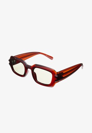 Gafas de sol de gran tamaño con tinte rojo, con montura angular pronunciada y tres líneas acentuadas verticales en cada brazo; lentes de color claro.