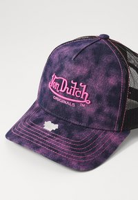 Vijolična kapica s poškodovanim izgledom in črnim mrežastim hrbtom, ki ima izrazit roza vezen logotip in kontrastne šiviljske detajle.