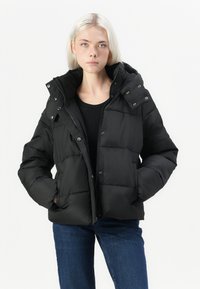 Fekete pufijacket kapucnival, cipzárral, patent gombokkal és steppelt kialakítással. Simább, Matt anyagból készült.