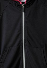 Giacca nera con zip e cappuccio foderato in rosa, dotata di zip argentata e due tasche laterali. Texture liscia e design a taglio atletico.