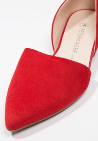 Chaussure plate en daim rouge à bout pointu avec un côté partiellement ouvert, dotée d'une semelle intérieure beige clair estampillée "Peter Kaiser".