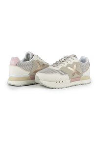 Sneaker in einem beige-, creme- und rosafarbenen Farbschema. Netzseitenteile, Lederakzente, flache Schnürsenkel und eine strukturierte Gummisohle für besseren Halt.