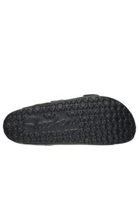 Scarpe Skechers con suola in gomma nera testurizzata, caratterizzate da un motivo floreale e dal nome del marchio in rilievo. Il design include cinghie laterali per una migliore vestibilità.