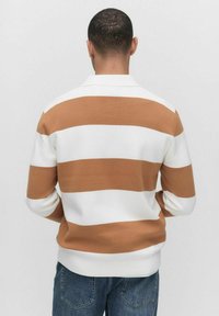 Långärmad tröja med breda horisontella ränder i vitt och beige, med en texturerad tyg och krage.