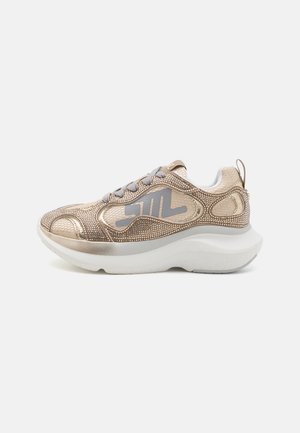 Arany fémes és hálós sneaker, strasszkövekkel díszítve, szürke fűzővel, vastag fehér talppal és hátsó húzófüllel, oldalnézetben bemutatva.