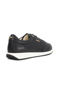 Black leather sneaker with white sole, gold "Dune" logo on side and heel, showing side and rear angles.