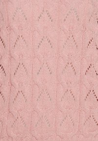 Tessuto lavorato a maglia di colore rosa chiaro con un motivo a diamante testurizzato, caratterizzato da punti aperti e bordi a scallop. Aspetto morbido e arioso.