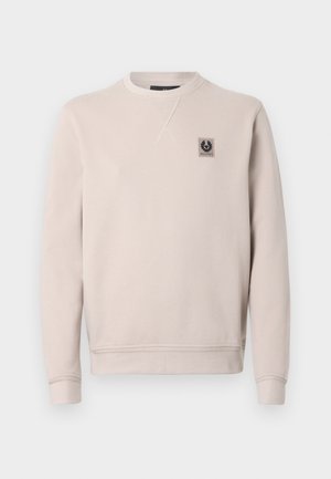 Light beige sweatshirt made of cotton. Features a crew neck, long sleeves, ribbed cuffs, and a small logo patch on the chest. Smooth texture.
