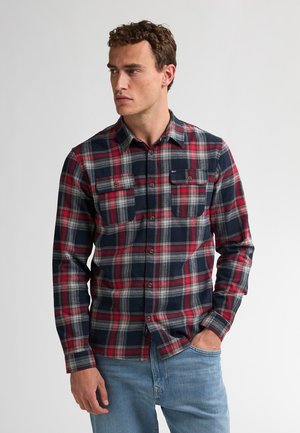 Camisa de franela a cuadros en rojo, azul marino y gris, con mangas largas, cuello de botón y dos bolsillos en el pecho. Tejido suave con patrón a cuadros.