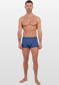 Pánské modré boxerky s elastickým pasem s logem, vyrobené z pružné látky. Mají přiléhavý střih a hladkou strukturu.