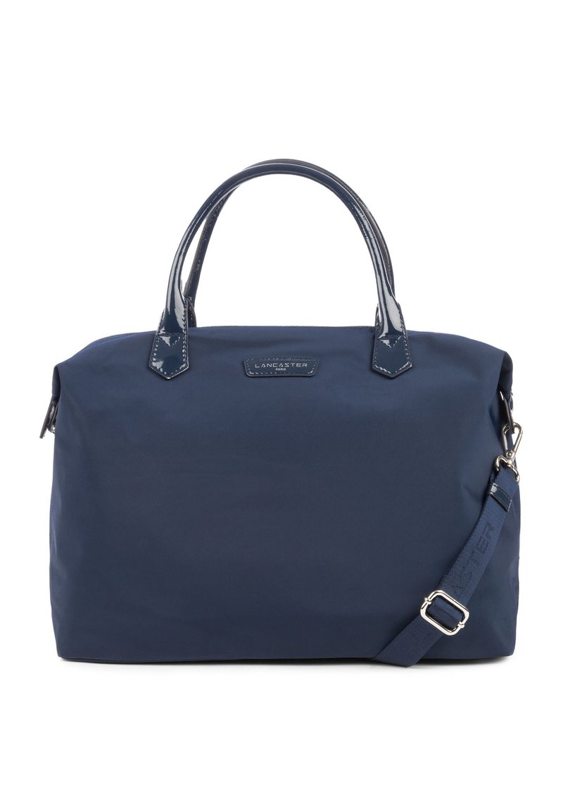 Sac à main en nylon bleu marine avec poignées et bandoulière en cuir verni, quincaillerie en métal, forme rectangulaire et détail du logo à l'avant.