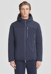 Veste à capuche bleu foncé avec fermeture éclair à l'avant, dotée de deux poches latérales et d'une poche poitrine. Réalisée en un tissu lisse et texturé.