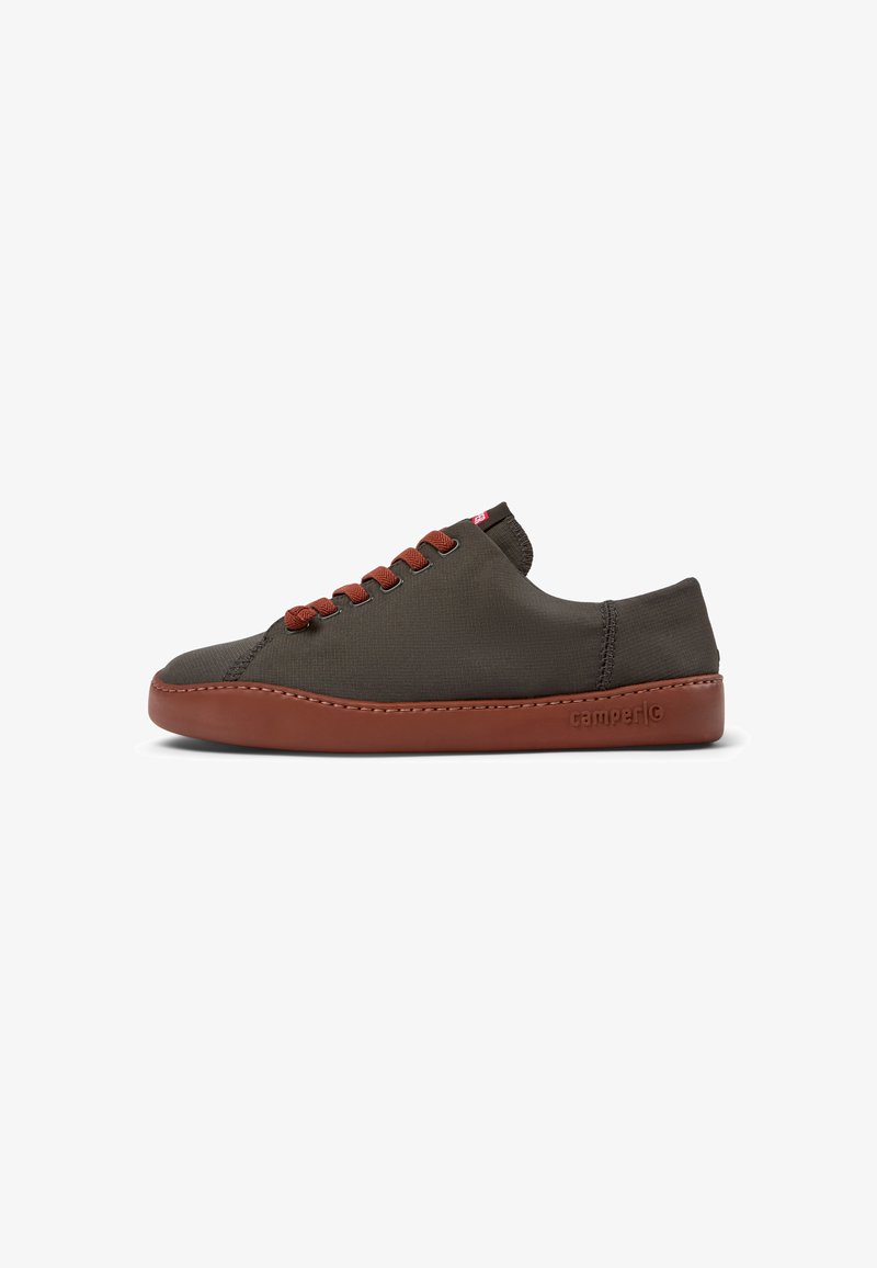 Olive green canvas sneaker with brown rubber sole, brown laces, and lightweight design. Features minimalist shape and stitched detailing.