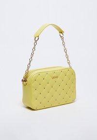Borsa a mano in finta pelle gialla trapuntata con tracolla a catena, dotata di hardware in tonalità oro, decorazioni con strass e chiusura con zip.