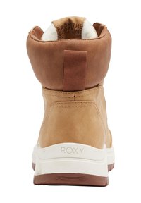 Braune Stiefelette aus Kunstleder mit einer weichen weißen Fleece-Fütterung, flacher weißer und brauner Gummisohle sowie einer Zuglasche hinten für einfaches Anziehen. Roxy-Logo sichtbar.