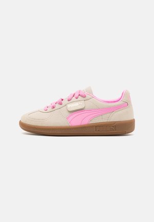 Baskets en daim beige avec des accents roses, dotées d'une semelle en caoutchouc, d'un bout rond et de lacets plats. Logo PUMA sur le côté et la languette.