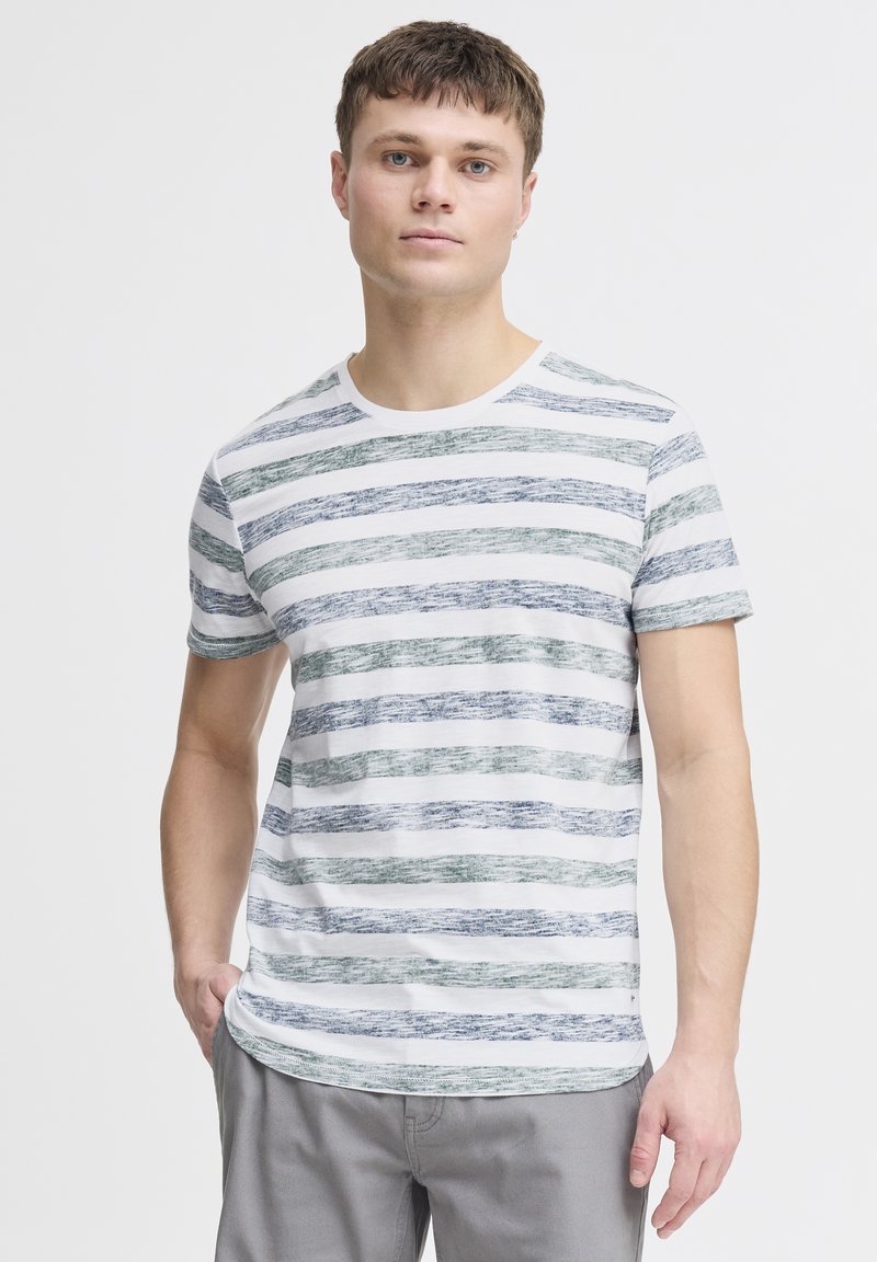 T-shirt rayé en blanc, vert et bleu. Caractéristiques des manches courtes, un col rond, et un tissu doux et texturé. Design simple et décontracté.