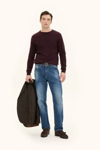 Bordeauxfarbener Pullover, hellblaue Jeans, braune Wildleder-Mokassins; hält ein dunkelbraunes kariertes Blazer. Einfaches, lässiges und abgestimmtes Outfit.