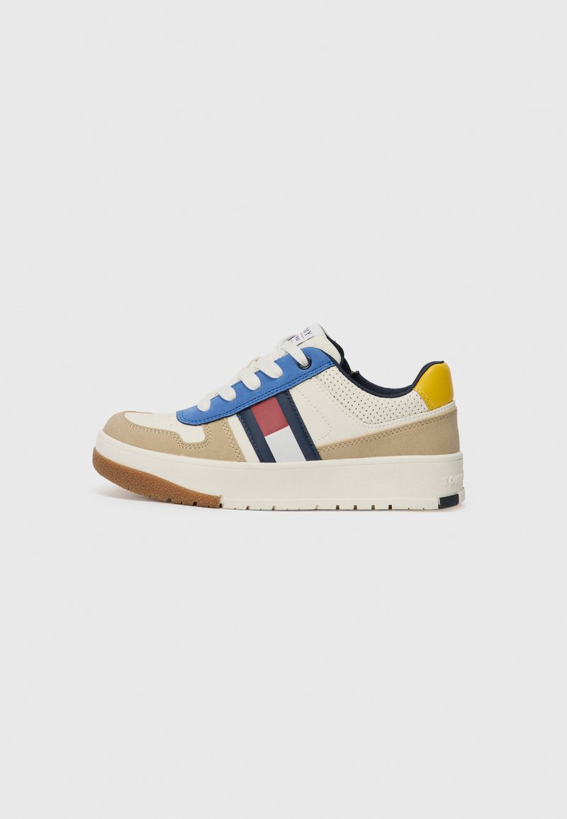 Baskets avec une tige crème, des accents bleus et rouges, des rayures marine, du daim beige, et une semelle en caoutchouc. Comprend des lacets ronds et des détails perforés.