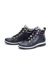 Bottes de randonnée en cuir bleu foncé avec des accents gris, équipées de garnitures dorées, d'un laçage et d'une semelle moulée pour l'adhérence.