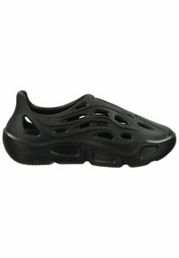 Chaussure noire à enfiler avec de multiples trous de ventilation et une semelle épaisse, présentant un design sculpté et futuriste.