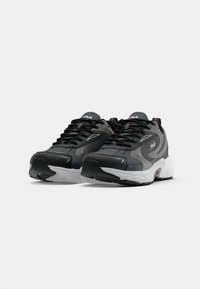 Ciemnoszare sportowe sneakersy z odblaskowymi akcentami, cushioned sole oraz teksturowanymi panelami. Posiadają czarne sznurówki i logo na języku.