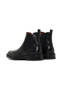 Botas Chelsea de cuero negro con un diseño elegante, paneles laterales elásticos, perforaciones decorativas y un acabado suave y pulido.