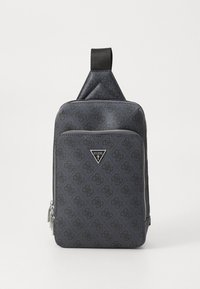 Tmavě šedá kabelka Guess přes rameno s potiskem loga, přední kapsa na zip, stříbrný zip a jeden černý ramenní řemínek.