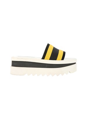 Platform slide sandal med tyk hvid sål og sort og gulstribet stofrem over foden.