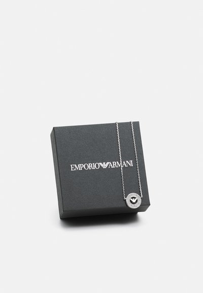 Silver pendant necklace with a circular design and textured border, displayed on a black Emporio Armani packaging box.