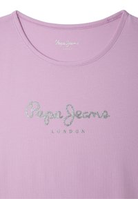 Šviesiai rožinė medvilninė marškinėliai su apvaliu kaklu ir trumpomis rankovėmis. Priekyje yra blizgūs sidabro spalvos „Pepe Jeans LONDON“ užrašai. Textūruota medžiaga.