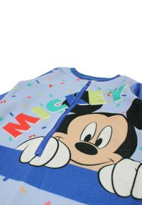Chemise bleu à manches courtes avec un grand motif de Mickey Mouse, des motifs colorés de confettis et une fermeture éclair à l'avant.