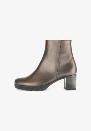 Bottine en bronze métallique avec une texture lisse, un bout arrondi et un large talon noir. Design minimaliste avec un détail de zip sur le côté.