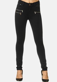 Zwarte skinny jeans met een gladde textuur, voorzien van metalen gouden ritssluitingen aan de voorkant en een klassieke knoopsluiting.
