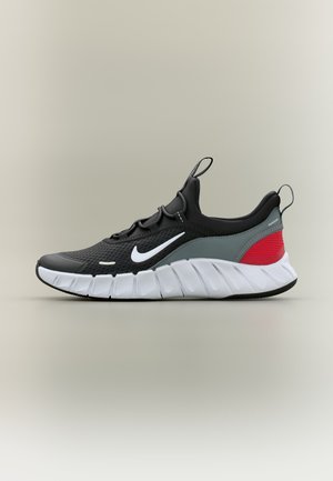 Čierna, sivá a červená športová obuv s bielou podrážkou a logom Nike, navrhnutá pre pohodlie a flexibilitu, bočný pohľad na neutrálnom pozadí.