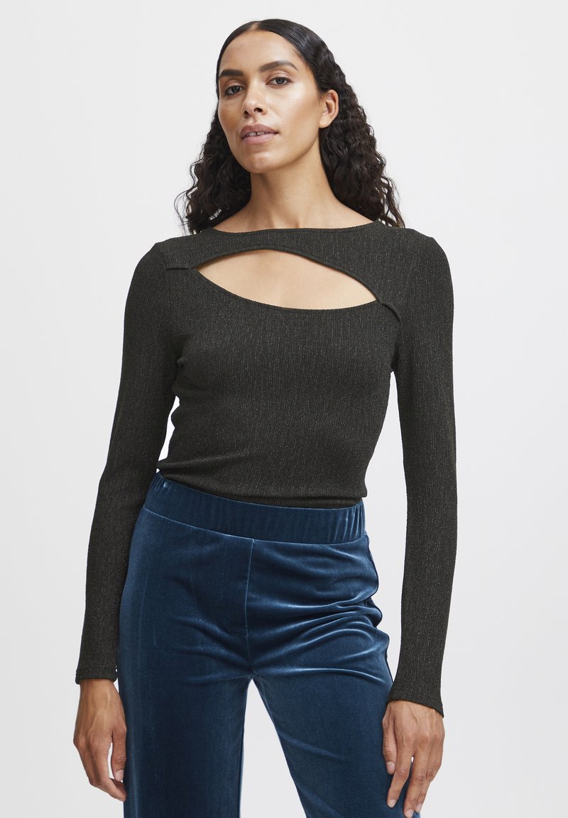 Zwarte lange mouwen top met een textuurafwerking en een uitsnede bij de halslijn, gecombineerd met blauwe pluche wijde broek.