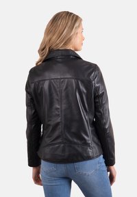 Black leather jacket with a smooth texture, fitted design, and long sleeves. Features a pointed collar and tailored back seams.