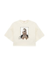 Afkortet creme t-shirt med korte ærmer, der har et grafisk motiv af en figur med en leopardmønstret sløjfe og tekst under billedet.