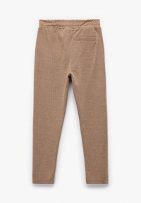 Brune mønstrede leggings med herringbone tekstur, der har en elastisk talje og en enkelt baglomme. Egnet til afslappet brug.