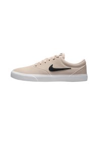 Zapatillas beige de material ante, con suela de goma blanca, swoosh negro en el lateral, punta redonda y seis ojales para los cordones.