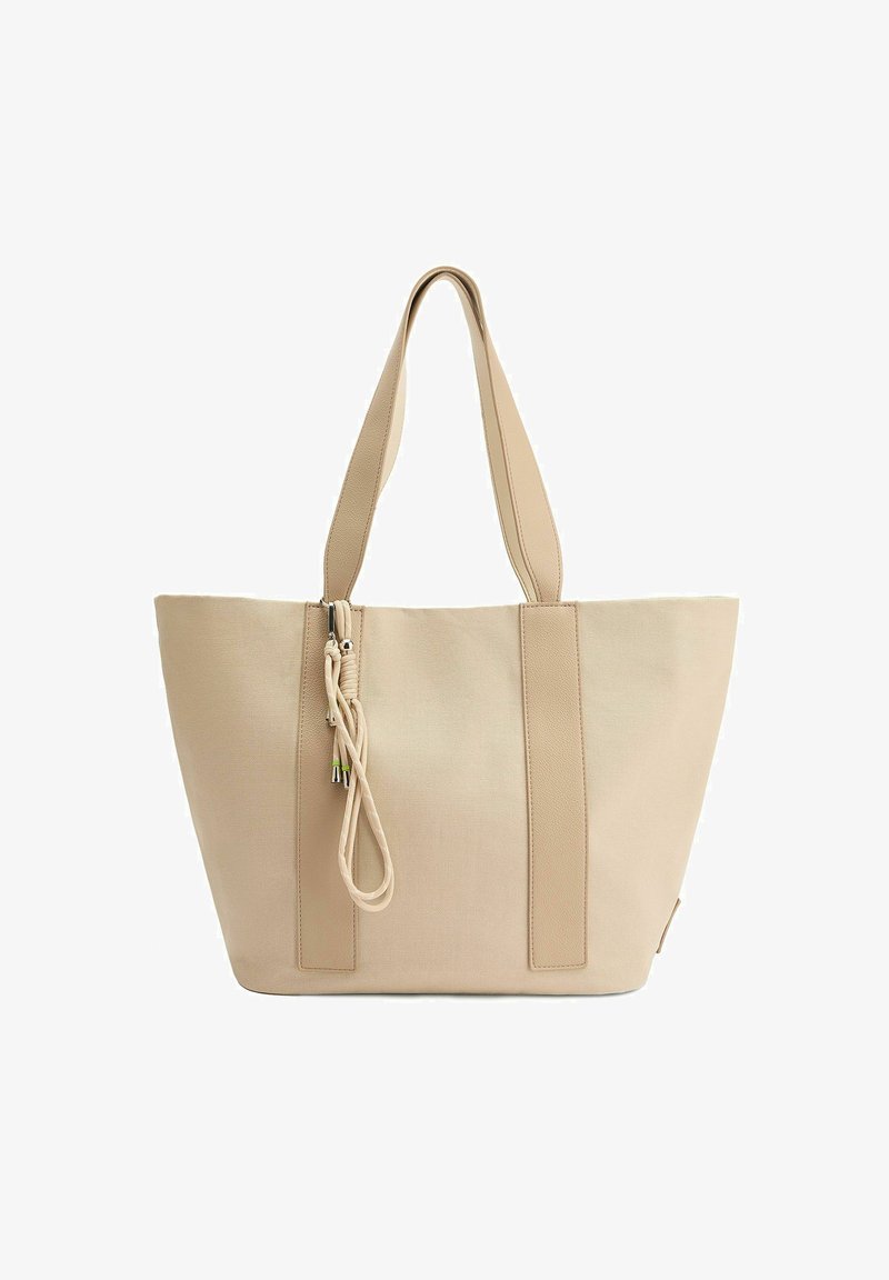 Sac fourre-tout beige en tissu lisse avec des poignées texturées contrastantes. Il dispose d'une fermeture zippée et d'un cordon décoratif avec des accents en métal.