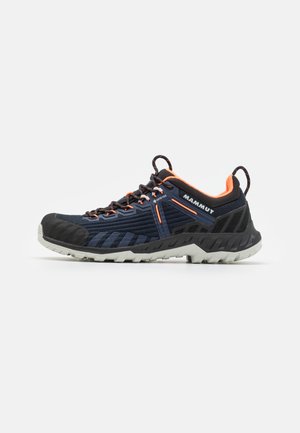 Herren Trailrunning-Schuh in Marineblau mit orangen Akzenten, strukturiertem Obermaterial, schwarzem Gummikappen und langlebiger weiß-grauer Außensohle für Traktion.