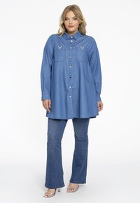 Jeanshemdkleid in Hellblau, mit zwei Brusttaschen, Knopfleiste und abgerundetem Saum. Lockere Passform mit langen Ärmeln.