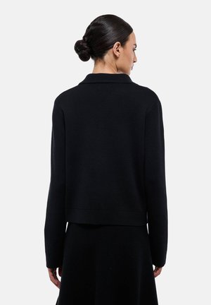Pull en maille noire avec col, au design court et aux manches longues. Tissu texturé avec une finition lisse, sans matériel visible.